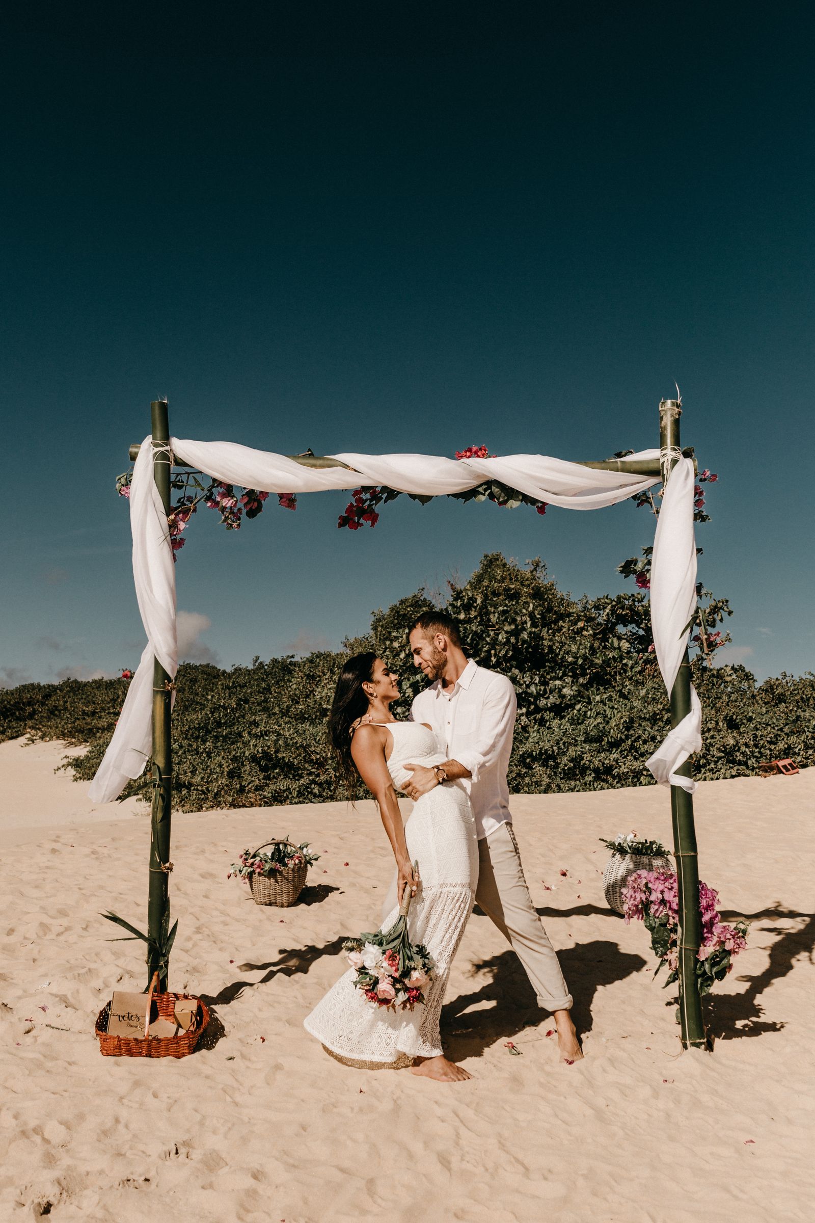 Bride and groom walking along the sand